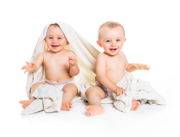 istock Twin baby under a towel. isolated on a white background 855243460