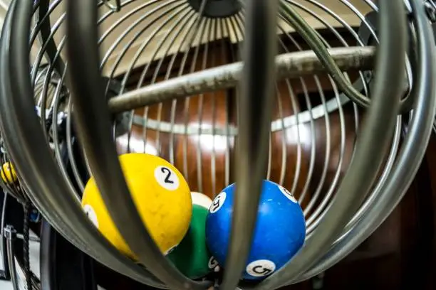 Old lottery equipment with some draw balls inside.