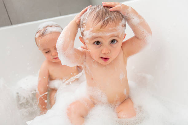 istock Two little boys having fun with water by taking bath in bathtub 855246568