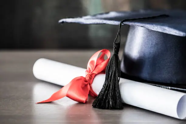 Photo of Graduation hat and diploma on table