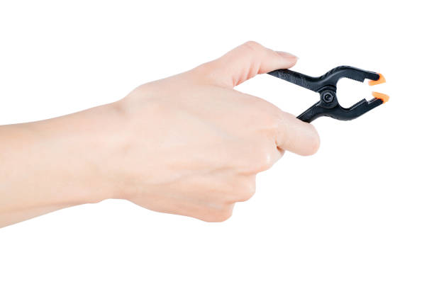 istock Woman hand holding black clamp, isolated with clipping path 855247422