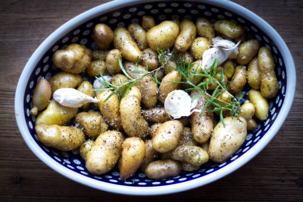 fingerling potatoes, garlic, rosemary in baking dish - fingerling imagens e fotografias de stock