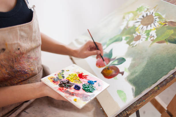 Female artist working in studio Female artist working in studio, drawing flowers. workshop art studio art paint stock pictures, royalty-free photos & images