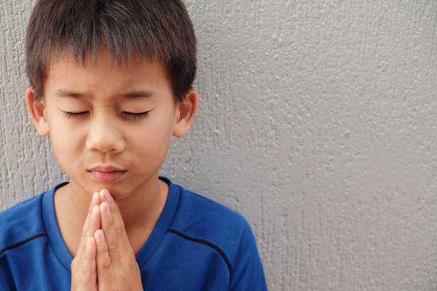 istock asian boy praying with eyes closed 855269736