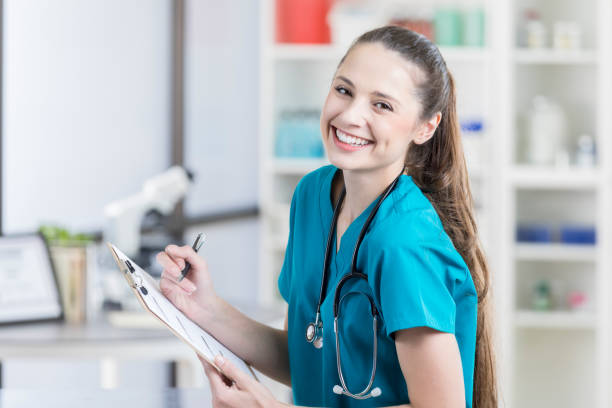 Beautiful veterinary nurse smiles for camera with clipboard