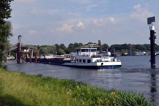Inland waterway vessel loading sand in Heijen, Holland