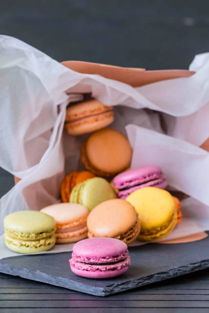 craft box filled with macaroons. french macaroons. dropped from gift box with colorful macarons on the black backgrou   nd. rainbow. - craft chocolate candy black box imagens e fotografias de stock