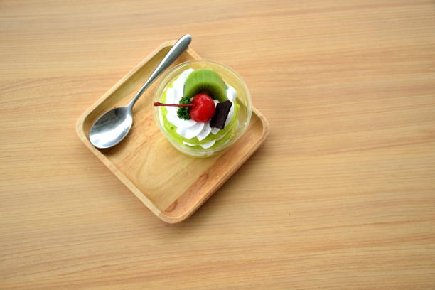 Three layer of green sofe cake with whipping cream and toping with chocolate cherry  and kiwi on wooden table Three layer of green sofe cake with whipping cream and toping with chocolate cherry  and kiwi on wooden table sofe stock pictures, royalty-free photos & images