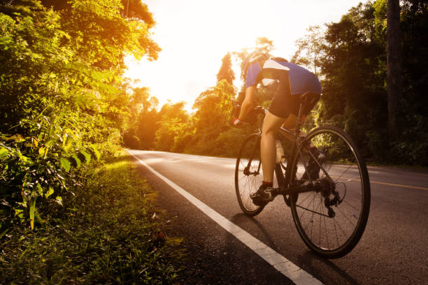 cycliste féminine cyclisme suis le chemin dans les bois et les montagnes - triathlon cycling bicycle competition photos et images de collection
