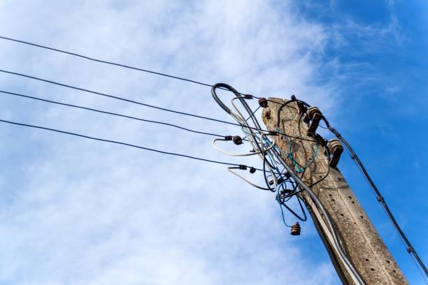 istock Concrete column of power line. Chaotic electrical connection. Tangle of wires. 855318438