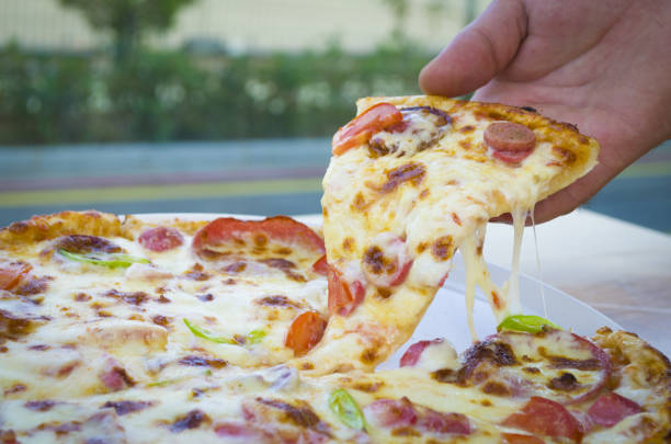 istock a slice of pizza in his hand a restaurant beautiful background 855318638