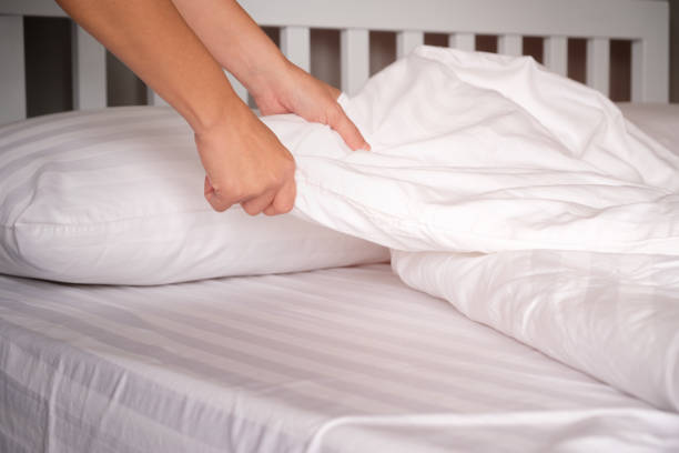 le mani delle casalinghe che cambiano lenzuola negli hotel. - lenzuolo foto e immagini stock