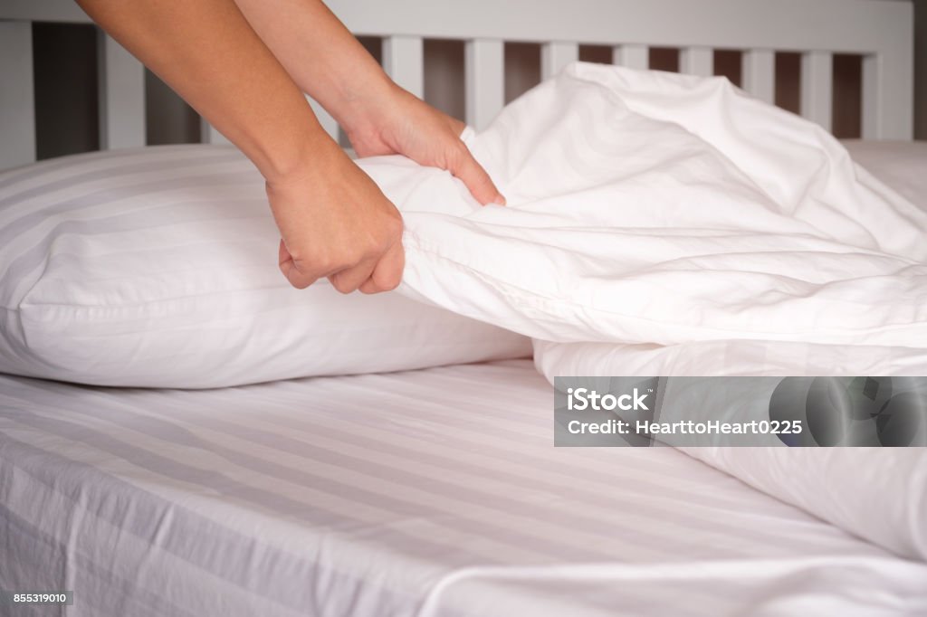 The hands of housewives who are changing sheets in hotels. Sheet - Bedding Stock Photo