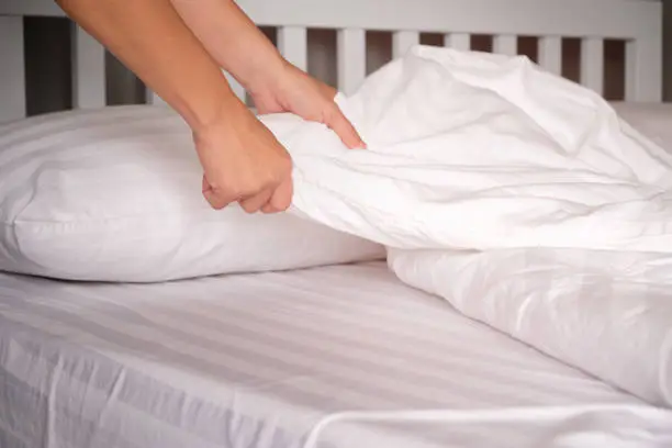 The hands of housewives who are changing sheets in hotels.