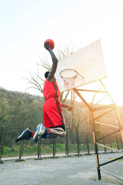 istock Basketball player making slam dunk on court, outdoors 855338520
