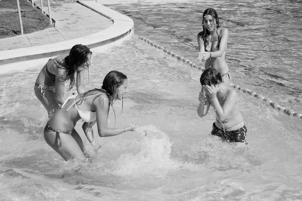 istock Three girls splashing water in swimming pool 855342406