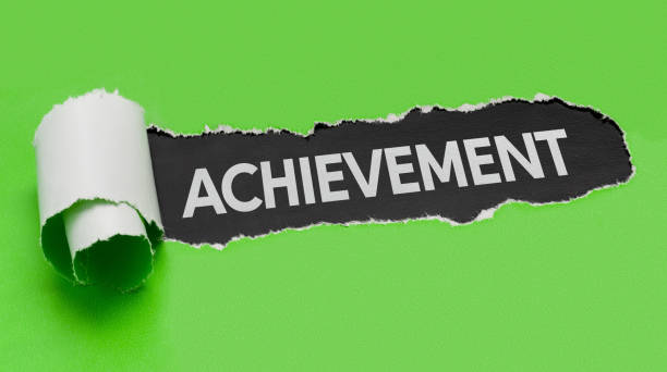 istock Torn green paper revealing the word Achievement 855342420