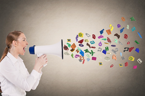 Businesswoman screaming into megaphone spilling out application icons