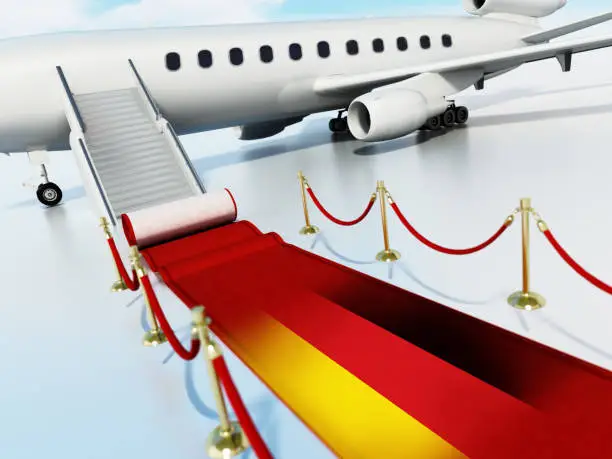 Photo of Red carpet with flag of Germany and velvet ropes laid in front of private jet door