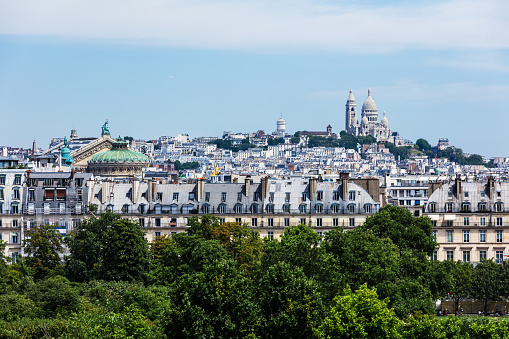 Panorama of Paris with Basilica of the Sacred Heart of Paris (Basilique du Sacre Coeur) on Montmartre hill and Palais Garnier opera house viewed from Orsay Museum. Paris, France