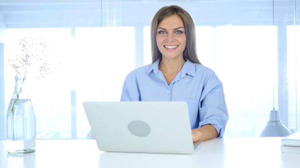 istock Beautiful Smiling Woman Looking at Camera in Office 855360048