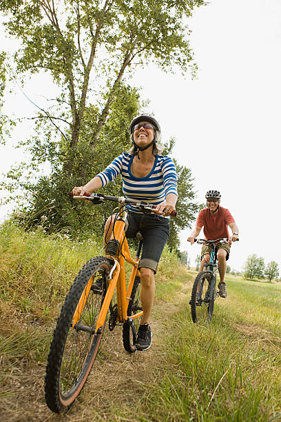 マウンテンバイクのカップル - retirement mature couple couple bicycle ストックフォトと画像