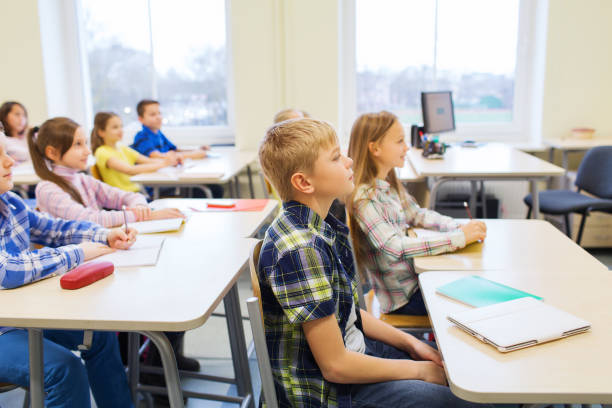 istock group of school kids with notebooks in classroom 855376520