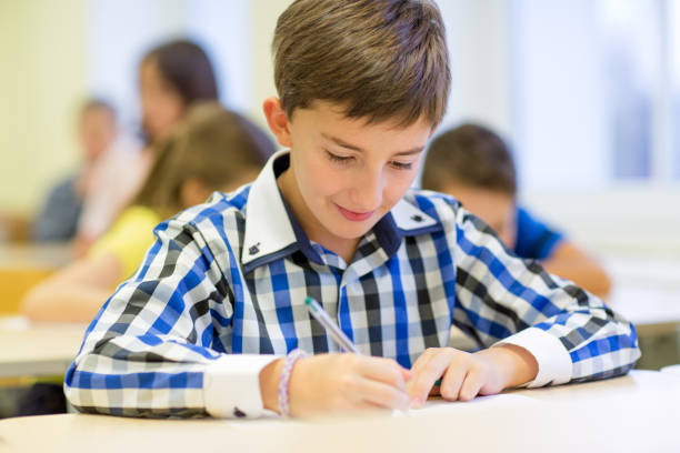 istock group of school kids writing test in classroom 855376580