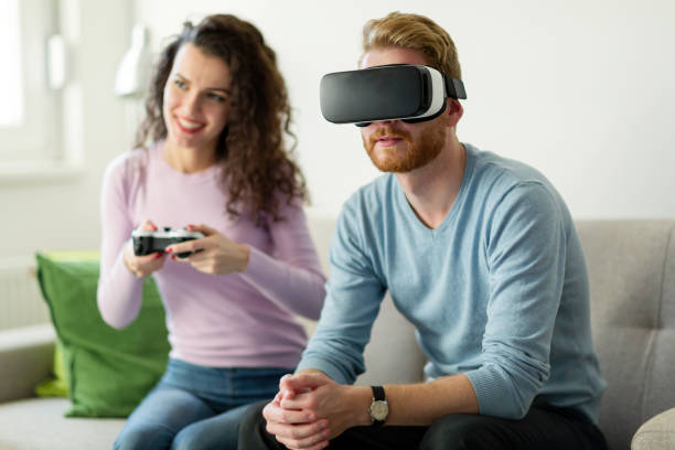 istock Happy young couple playing video games with virtual reality headsets 855379204