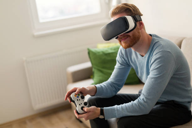 istock Handsome man playing video games with virtual reality headset 855379462