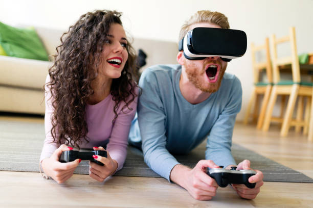 istock Happy young couple playing video games with virtual reality headsets 855379870