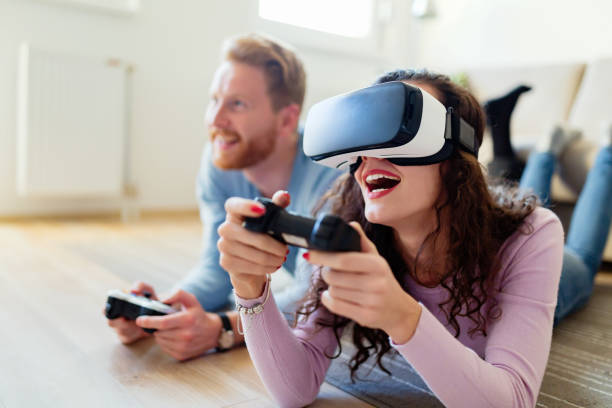 istock Happy young couple playing video games with virtual reality headsets 855381916