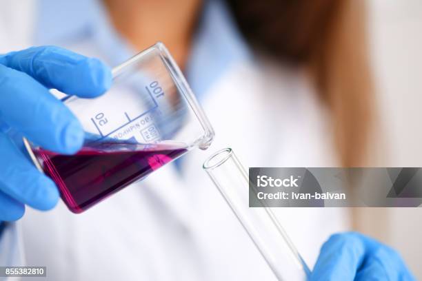 Female Chemist Holds Test Tube Of Glass In His Hand Overflows A Liquid Stock Photo - Download Image Now