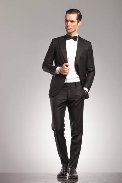 istock man in tuxedo  looks away while holding his colllar 855386188