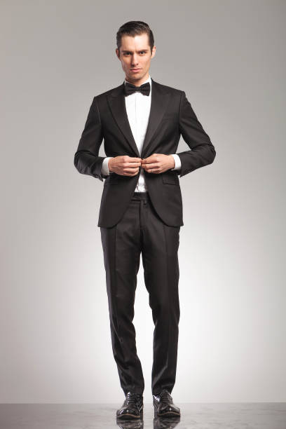 istock sexy young man in tuxedo and bowtie buttoning his suit 855386214