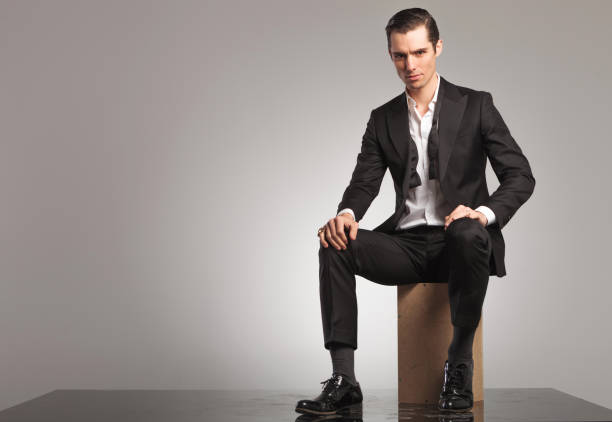 istock man in open tuxedo and undone bowtie sitting 855386564
