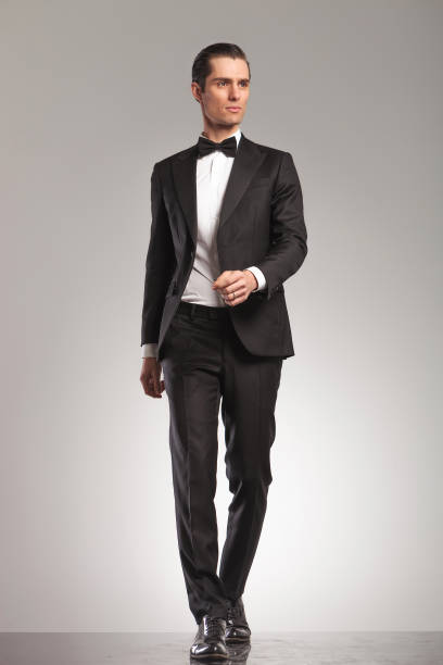 istock walking elegant man in tuxedo is looking up to side 855388722