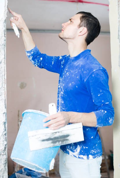 istock Plasterer renovating indoor doorway 855394030