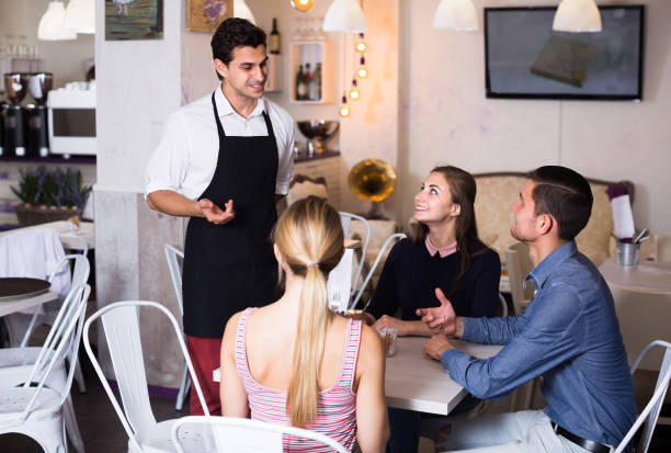 istock Adult waiter is greeting visitors and taking order. 855394404