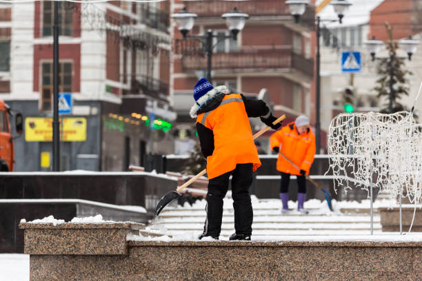 People-janitors in orange jackets cleaned the city from snow with shovels. Winter city after a snowfall People-janitors in orange jackets cleaned the city from snow with shovels. Winter city after a snowfall. street sweeper stock pictures, royalty-free photos & images