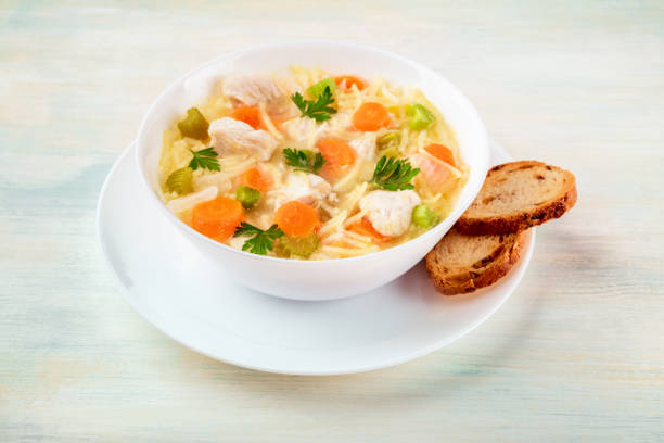 istock Chicken soup with noodles and bread on a light background 855410084