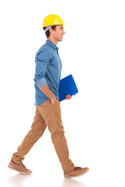 side view of a  construction engineering student walking with clipboard side view of a young construction engineering student walking with clipboard  on white background people laughing hard stock pictures, royalty-free photos & images