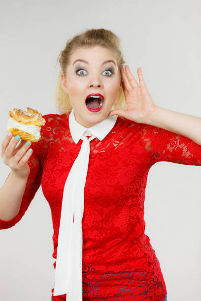 istock Funny woman holds cream puff cake 855417650