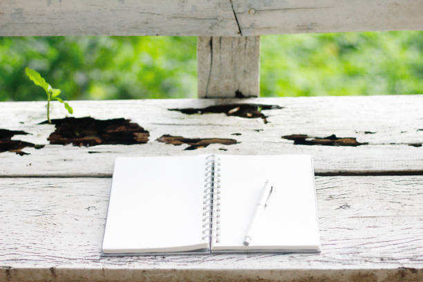 istock Stock photo :Open Notebook and white pen on old wooden background. 855420334