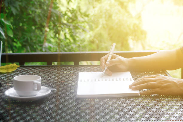 istock Stock photo :Coffee cup with closeup man writing a notebook on vintage table. 855421674