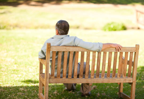 istock Elderly man sitting on the bench with his back to the camera 855421678