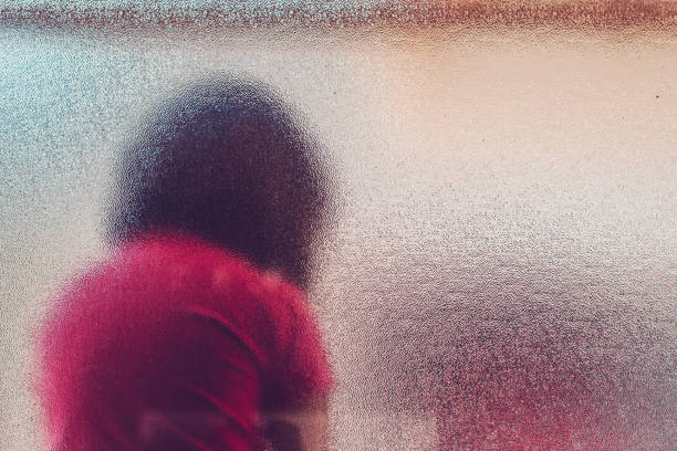 ステンド グラスの窓の後ろに認識できない悲しい自閉症の女の子のシルエット - unrecognizable person one person child childhood ストックフォトと画像