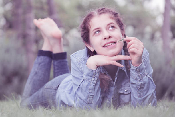 retrato de adolescente mientras se está acostado en el parque verde del verano - m14 fotografías e imágenes de stock