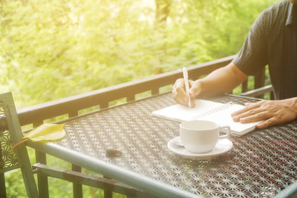 istock Stock photo :
Coffee cup with closeup man writing a notebook on vintage table. 855424448