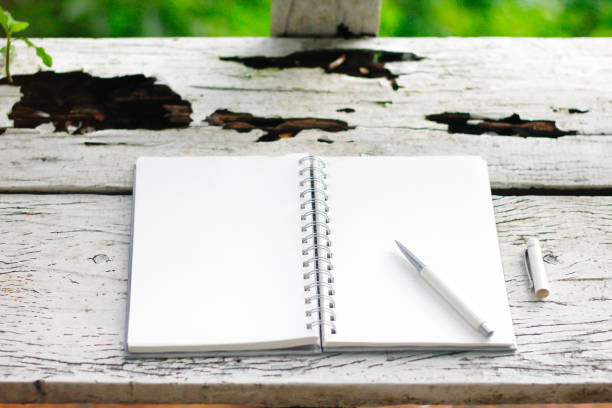 istock Stock photo :
Open Notebook and white pen on old wooden background. 855424516